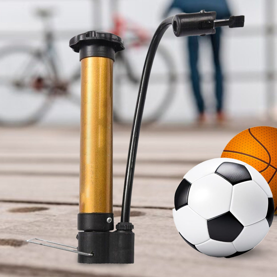 Compact metal hand air pump inflating a basketball on a court.