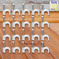 Close-up of steel nail gripping a plastic cable clip for dependable wire holding