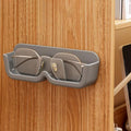 Compact eyewear organizer mounted on wall holding sunglasses