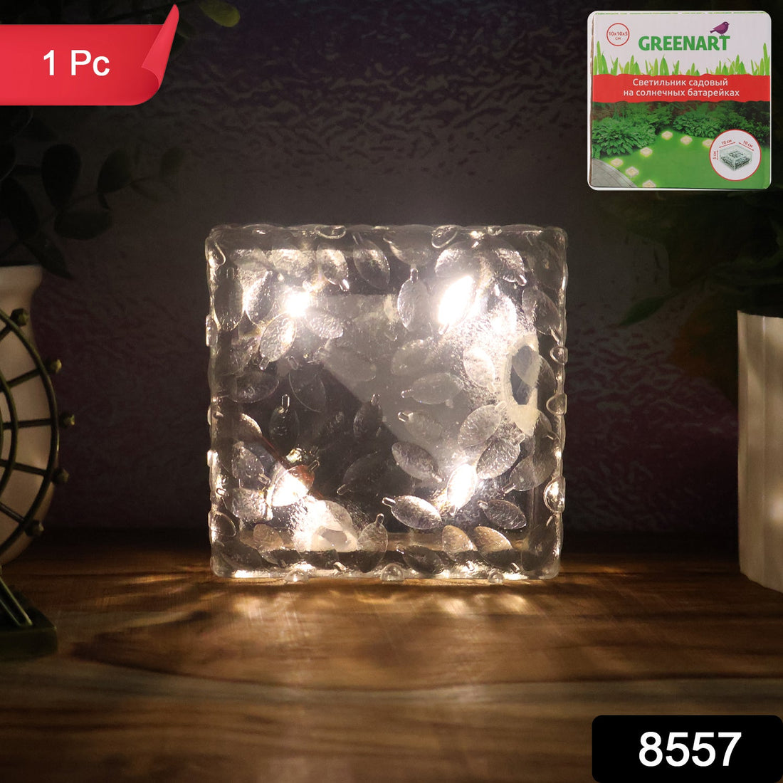 A single ice cube shaped solar garden light glowing warmly on a dark surface.