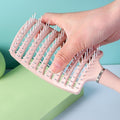 Massage hair comb held by hand showing anti-slip handle for comfortable styling