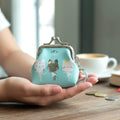 Portable coin pouch featuring cartoon cat print and metal clasp