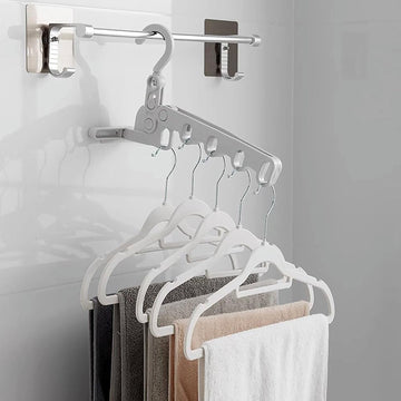 Foldable clothes hanger with 5 holes, shown extended for use in a closet.