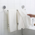 Towel rack bar installed on bathroom wall using adhesive mount