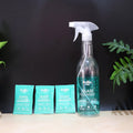 Refill kit sachets dissolving in water to create glass cleaning solution.