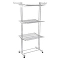 The 3-tier stainless steel drying rack with wheels, fully loaded with laundry.