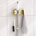 Space saving broom and mop hanger wall mounted with self adhesive base