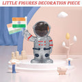 Solar powered astronaut figurine waving Indian flag on car dashboard