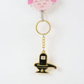 Golden Shivling keychain displayed on white surface showing metal craftsmanship