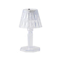 A compact crystal table lamp reflecting light onto a wall.