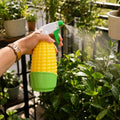 Hand using water spray for plants, demonstrating fine mist feature.
