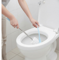 The toilet brush with holder in a clean, minimalist bathroom setting.