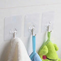 A single strong stainless steel adhesive hook holding a kitchen utensil on a tiled wall.