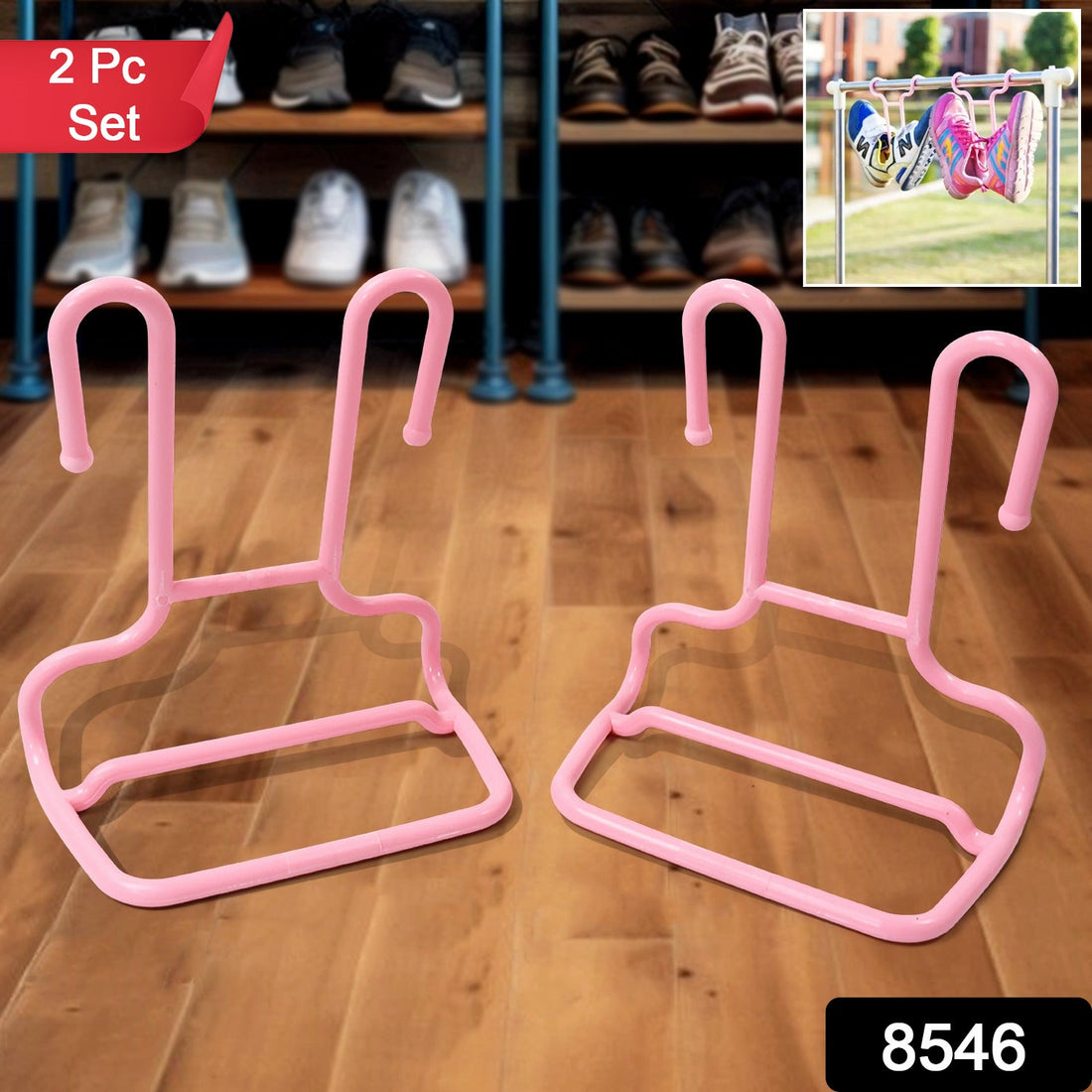 A pair of grey canvas shoes and pink sandals hang from green and pink plastic Organivo shoe drying racks on a metal rod.