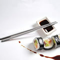 Reusable stainless steel chopsticks neatly placed on a chopstick rest.