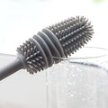 Hand holding a bottle cleaning brush, demonstrating its comfortable grip.