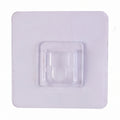 Transparent wall hook attached to a smooth surface for organization.