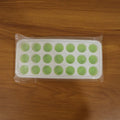 Close-up of the plastic ice cube tray's round molds, ready for filling.