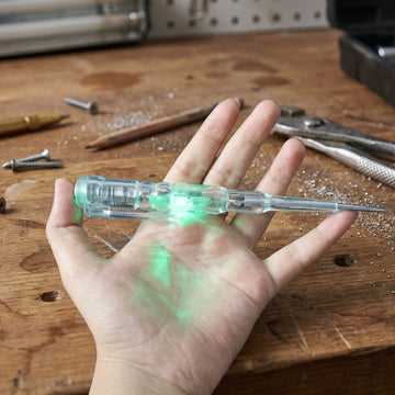 Digital voltage tester pen detecting electricity on electrical outlet with LED lights
