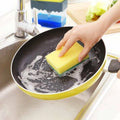 Compact soap dispenser and sponge holder filled with dish soap next to a kitchen sink.