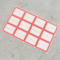 Close-up view of red and white rectangular self-adhesive label stickers