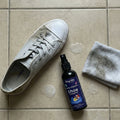 Shoe Cleaner Spray bottle positioned next to clean shoes