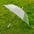 Close-up of curved handle on transparent dome umbrella for comfortable grip