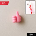 Pink thumb hook cable holder securely mounted on a wall surface