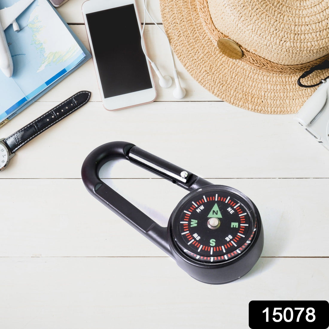 Mini compass with clip attached to a backpack strap, showing its compact size for outdoor use.